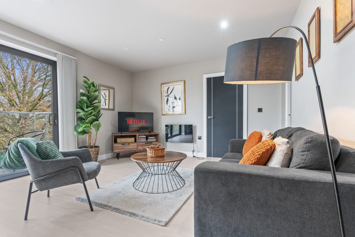 Living room with a grey sofa, armchair and TV